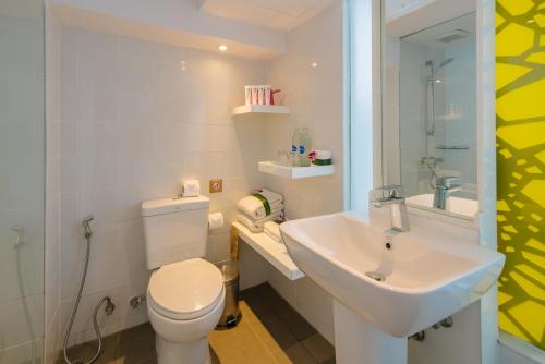 a bathroom with a white toilet and a sink at Burasari Phuket Resort & Spa in Patong Beach
