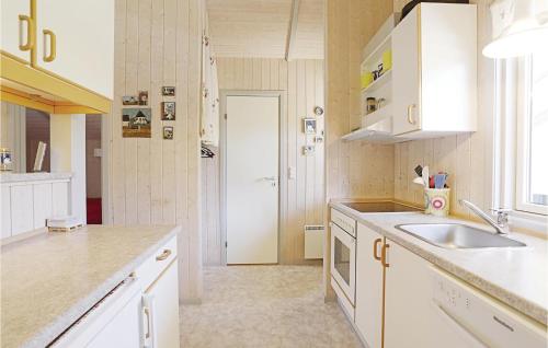 SnogebækにあるLovely Home In Nex With Kitchenの白いキャビネットとシンク付きのキッチン