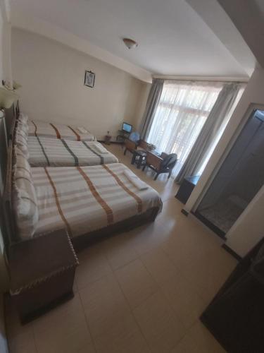a bedroom with a large bed and a living room at Honey Guest House in Lalībela