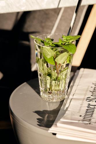 a glass vase filled with greens sitting on top of a keyboard at Just Eleven in Sankt Peter-Ording