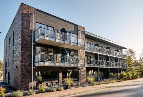 a brick building with a balcony on the side of it at Just Eleven in Sankt Peter-Ording