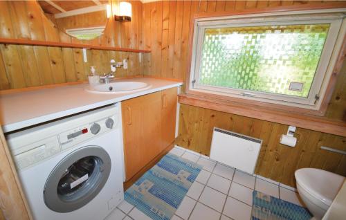 a bathroom with a washing machine and a sink at Nice Home In Nakskov With 2 Bedrooms in Kappel