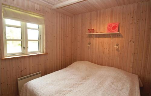 Bøtø ByにあるBeautiful Home In Vggerlse With Kitchenのウッドパネルのベッドルーム1室、窓付きのベッド1台が備わります。