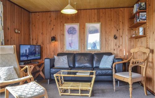 a living room with a couch and a tv at Holiday Home Arvidvej Denmk Xii in Bjerregård