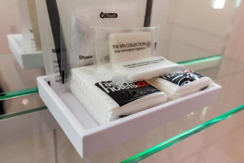 a shelf in a bathroom with towels and books at Hôtel Les Nations in Geneva