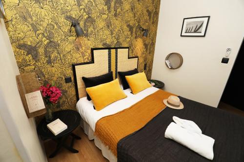 a bedroom with a large bed with yellow pillows at Etche Ona in Pyla-sur-Mer