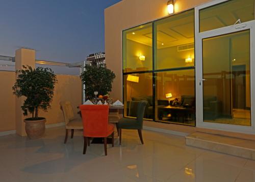 a patio with a table and chairs on a building at Swiss Flora Inn Hotel Riyadh in Riyadh