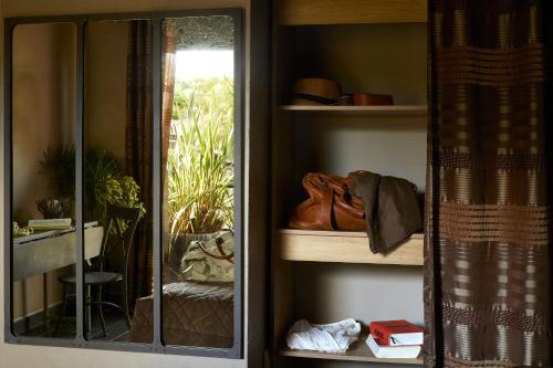 a room with a shelf with a mirror at Hôtel E Tre Stelle in Bonifacio