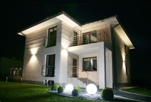 a large house with lights in front of it at night at Willa-Wita in Kalwaria Zebrzydowska