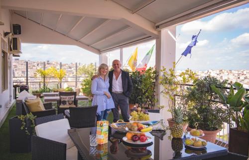 a man and a woman standing on a balcony at B&B Panoramic in Valguarnera Caropepe