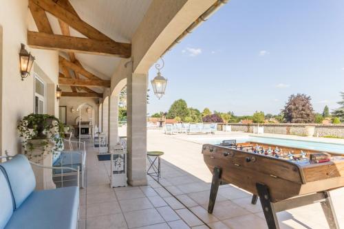 une terrasse avec un billard et une piscine dans l'établissement Grande villa d'exception en Normandie tennis, piscine, jacuzzi, salle de fitness, à Muids