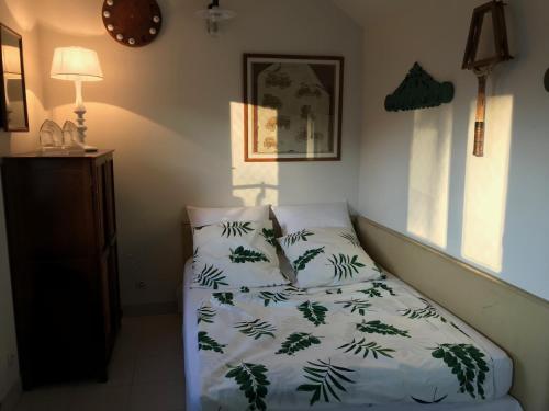 a bedroom with a bed with a green and white blanket at Grande villa d'exception en Normandie tennis, piscine, jacuzzi, salle de fitness in Muids