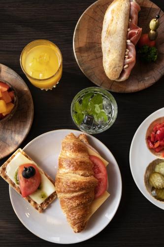 Una mesa cubierta con platos de comida sobre una mesa. en Quentin Amsterdam Hotel, en Ámsterdam