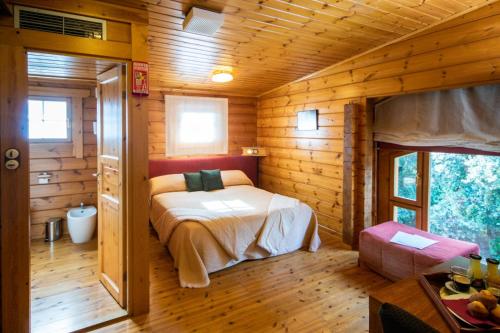 a bedroom with a bed in a wooden cabin at Hotel Somlom - ECO Friendly Montseny in Sant Esteve de Palautordera