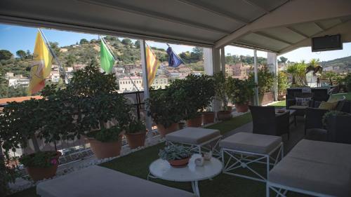 a balcony with tables and chairs and potted plants at B&B Panoramic in Valguarnera Caropepe