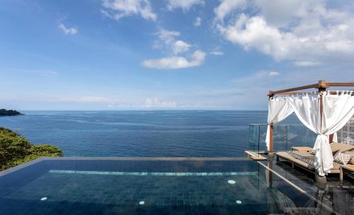 a swimming pool with a view of the ocean at The Shore At Katathani - Adult Only - SHA Extra Plus in Kata Beach