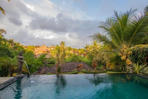a swimming pool in front of a villa at Kukuh House Ubud in Ubud