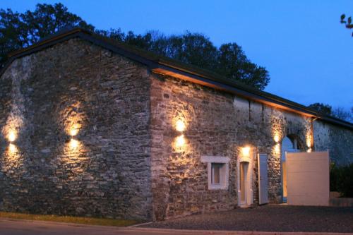 an old stone building with lights on it at koekoelavache holiday home in Vielsalm