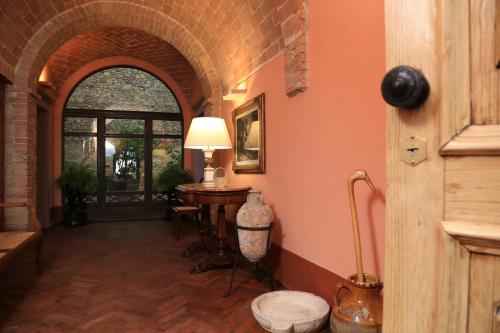 a hallway with an archway and a table with a lamp at Villa Giuncheto in Corsano
