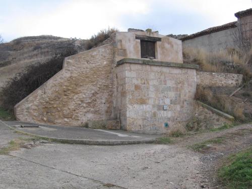 an old stone building on a hill with a dirt road at Casa rural L´Amparo -3 espigas- Categoría superior-15 personas in Navarrete del Río