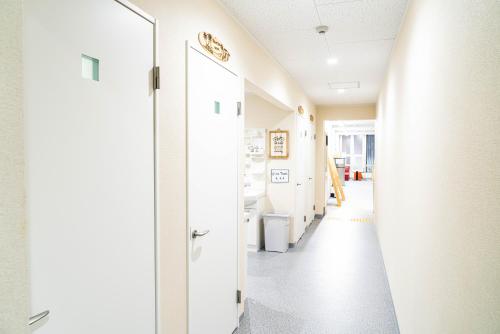 a hallway in a hospital with a door open at ONE HOSTEL Himeji ワンホステル姫路 in Himeji