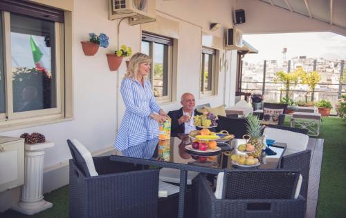 a woman standing next to a table with a man at B&B Panoramic in Valguarnera Caropepe
