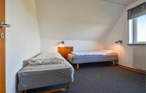 2 Einzelbetten in einem Zimmer mit Fenster in der Unterkunft Vejlgrd in Nørre Lyngvig