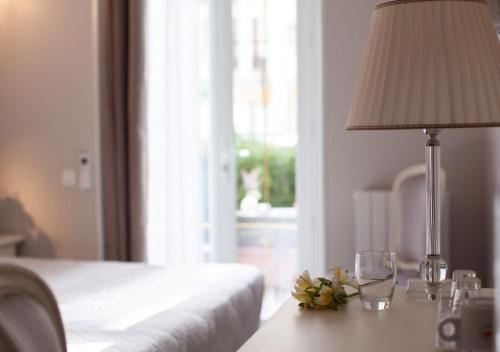 a bedroom with a table with a lamp and wine glasses at Hôtel restaurant Oasis in Nice