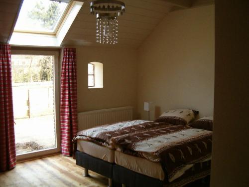 um quarto com uma cama e uma grande janela em Bed and Breakfast Annen em Annen