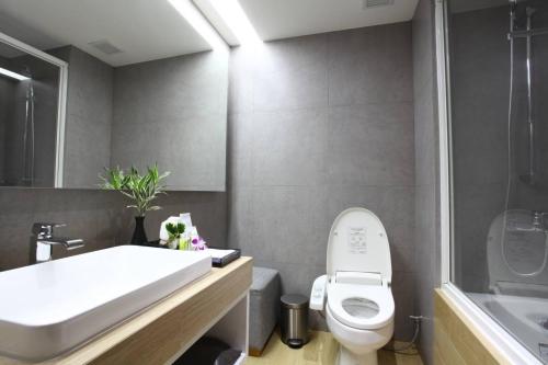 a bathroom with a white toilet and a sink at The Four Wings Hotel Bangkok in Bangkok