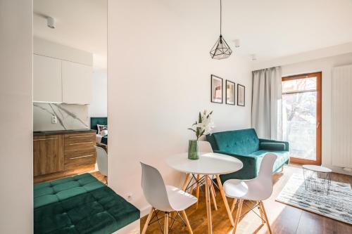 - un salon avec une table et un canapé vert dans l'établissement Homewell Apartments Dominikańska, à Poznań