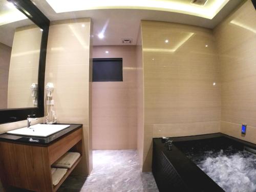 a bathroom with a sink and a bath tub at Song Xia Motel in Dali