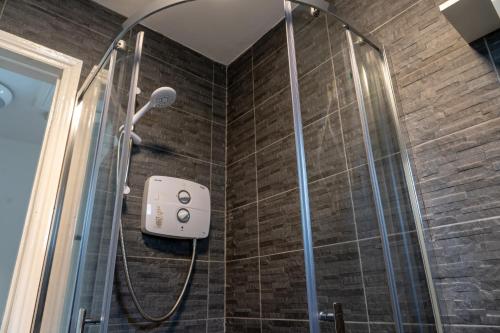 a shower in a bathroom with a shower head at Liberty Townhouses in Dublin