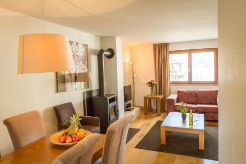 a living room with a table and a couch at Apart Holidays - Marina Walensee in Unterterzen