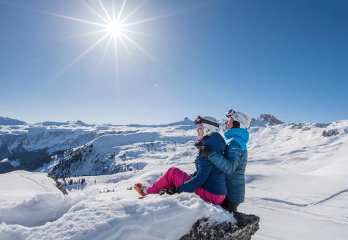 two people sitting on top of a snow covered mountain at Apart Holidays - Marina Walensee in Unterterzen