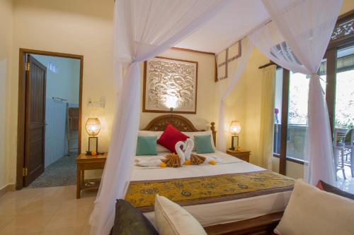 a bedroom with a bed with a canopy at Kukuh House Ubud in Ubud