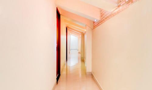 a hallway with white walls and a doorway at Itsy Hotels Aditya in Nagpur