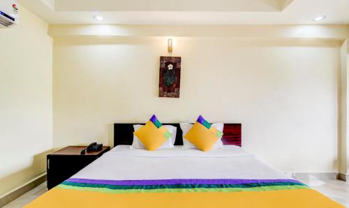 a bedroom with a large bed with colorful pillows at Itsy Hotels Aditya in Nagpur