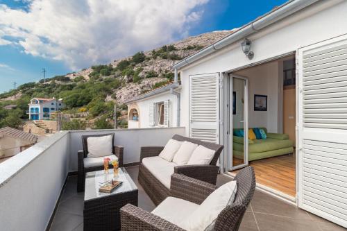 a balcony with chairs and a table and a couch at Mirta in Stara Baška