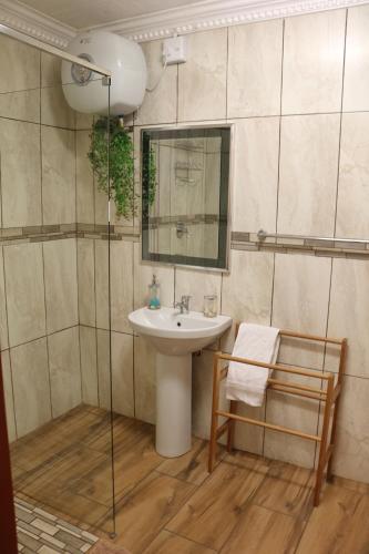 a bathroom with a sink and a mirror and a chair at Kairos Home in Middelburg