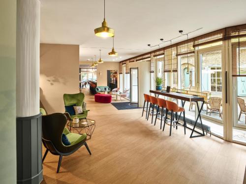 an open living room with a table and chairs at MAXX Hotel Sanssouci Potsdam in Potsdam