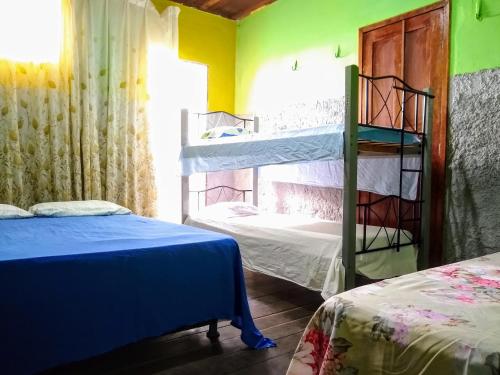 Praieiro Hostel Albergue في بارنايبا: غرفة بسريرين بطابقين ونافذة
