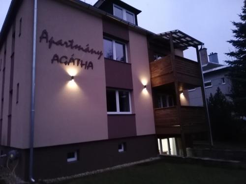 a building with a sign on the side of it at Apartmany Agatha in Loučná nad Desnou