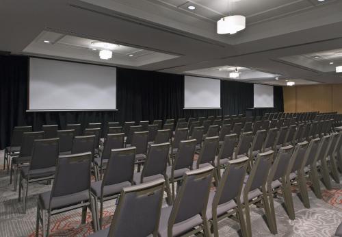 an empty conference room with chairs and a screen at Sofitel Noosa Pacific Resort in Noosa Heads