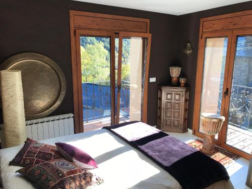 1 dormitorio con 1 cama y algunas ventanas en Casa Rustica Cabanes, en Ordino