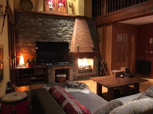 a living room with a fireplace and a television at Casa Rustica Cabanes in Ordino