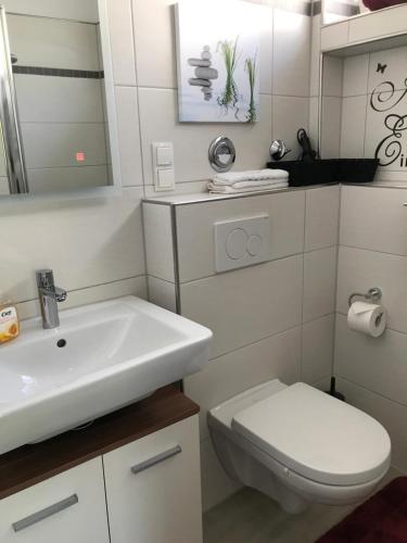 ein weißes Badezimmer mit Waschbecken und Toilette in der Unterkunft Moselnest in Cochem