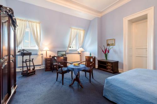 a bedroom with a bed and a table and chairs at Schlosshotel Ralswiek in Ralswiek