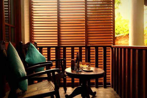 a table and chairs in a room with a window at Moonstone Villas in Tangalle