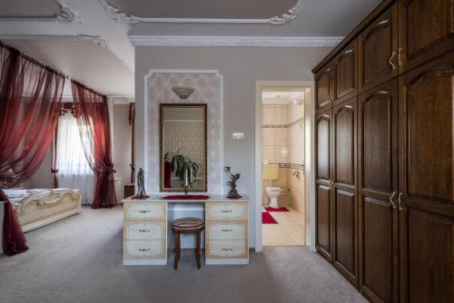 a bedroom with a vanity and a mirror and a bed at Hotel Bíbic és Tüskevár Étterem és Horgásztó in Nyíregyháza